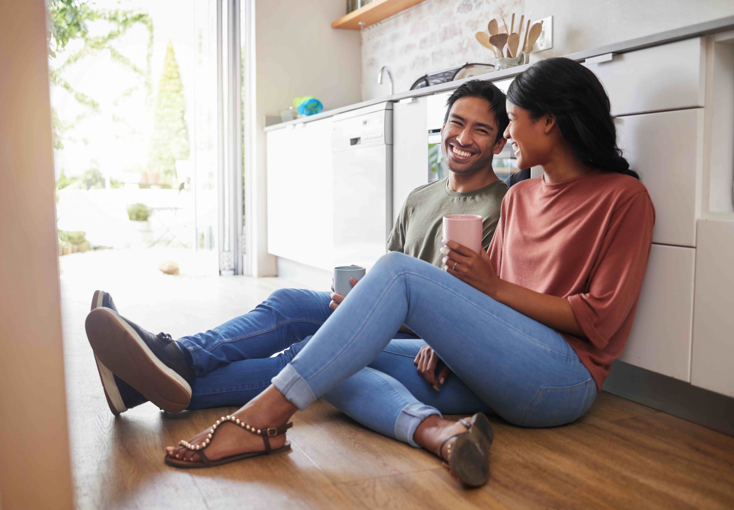 Couple happily having a conversation in their kitchen.